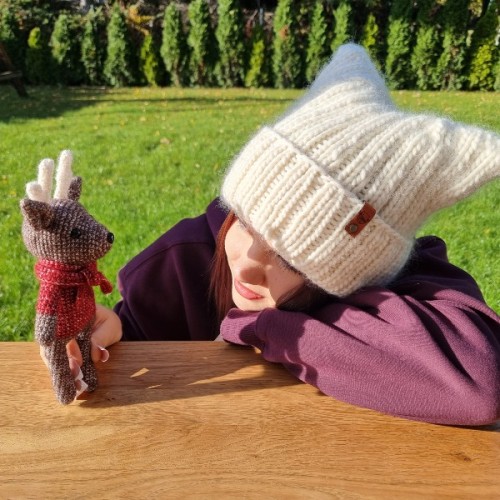 Modelka w białej czapce wykonanej według wzoru Czapa Kitty by Prezesowa, ujęcie w plenerze, produkt  Mila Druciarnia