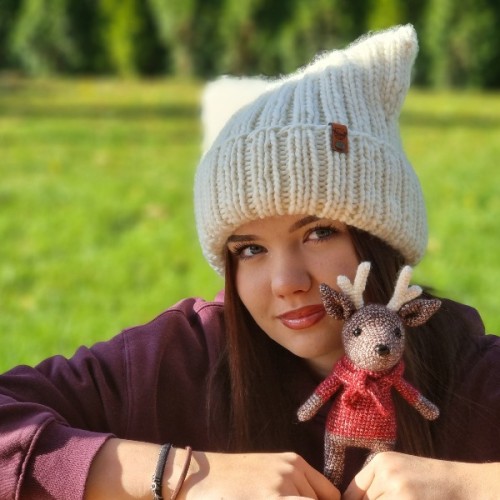 Biała czapka wykonana na drutach według wzoru Czapa Kitty by Prezesowa, prezentacja na modelce w plenerze, Mila Druciarnia